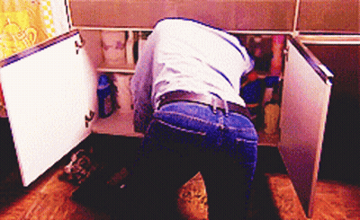Man In Blue Shirt Looking Under Sink GIF