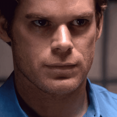 Man In Blue Shirt Looks At Camera GIF