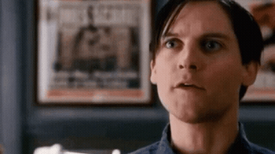 Man In Blue Shirt Making Funny Face At Newspaper GIF