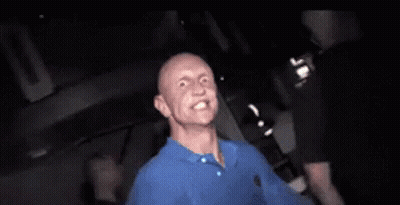 Man In Blue Shirt Making Funny Face In Dark Room GIF