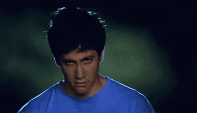 Man In Blue Shirt Making Funny Face In Dark Room GIF
