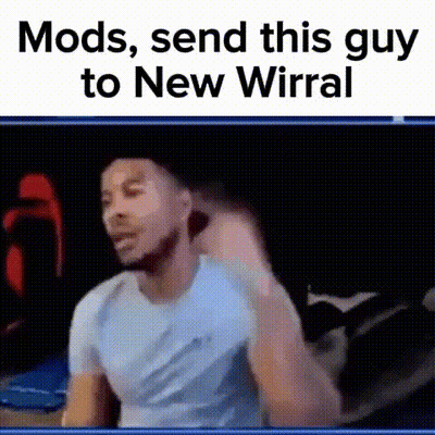Man In Blue Shirt Making Funny Face Sitting On Bed GIF