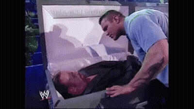Man In Blue Shirt Next To Coffin GIF