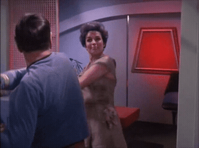 Man In Blue Shirt Next To Woman In Brown Dress GIF