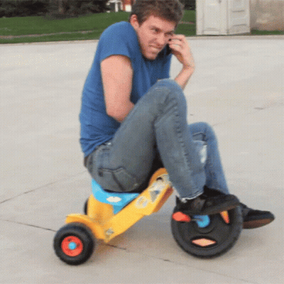 Man In Blue Shirt On Yellow Tricycle GIF
