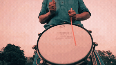 Man In Blue Shirt Playing Drum Saying Narayanan GIF