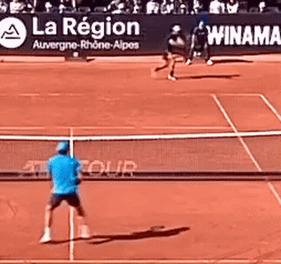 Man In Blue Shirt Playing Tennis With La Region Sign GIF