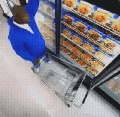 Man In Blue Shirt Pushing Shopping Cart In Store GIF