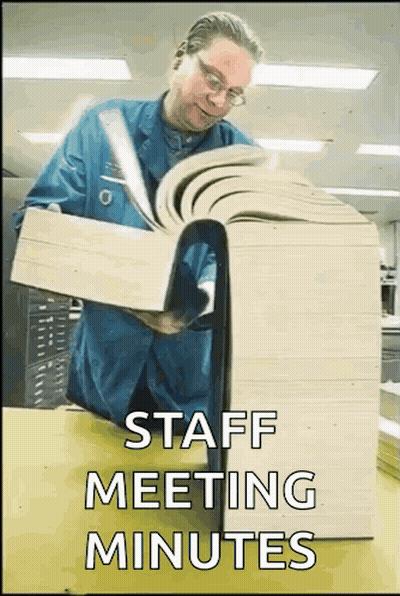 Man In Blue Shirt Reading Large Book Saying Staff Meeting Minutes GIF