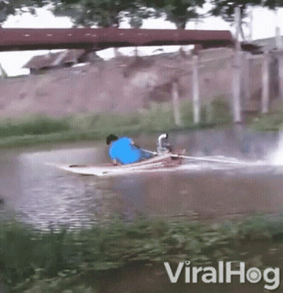 Man In Blue Shirt Riding Boat In River GIF