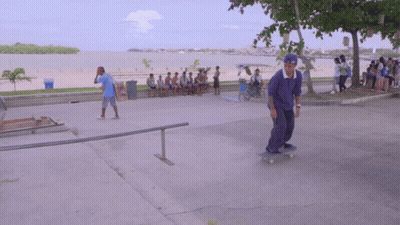 Man In Blue Shirt Riding Skateboard Down Ramp GIF