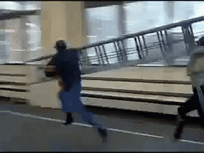 Man In Blue Shirt Running Down Street With Stairs GIF