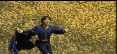 Man In Blue Shirt Running Through Yellow Flowers GIF