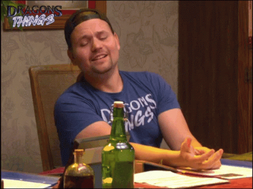 Man In Blue Shirt Saying Dragons Things Sits At Table GIF