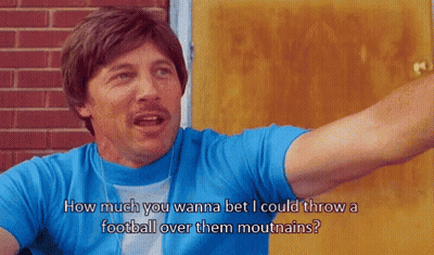 Man In Blue Shirt Saying How Much You Wanna Bet I Could Throw A Football Over Them Mouthains GIF