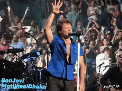 Man in Blue Shirt Singing Bon Jovi Into Microphone