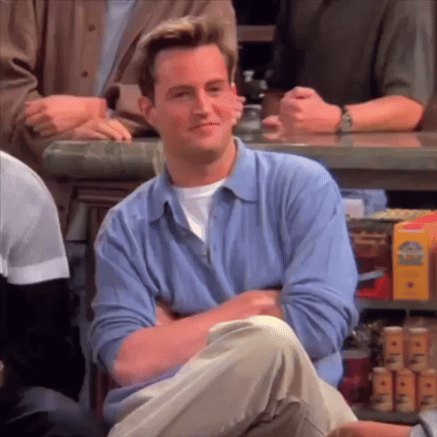 Man In Blue Shirt Sitting At Bar With Arms Crossed GIF