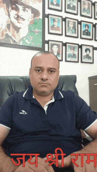 Man In Blue Shirt Sitting Beside Soldiers Wall With Word Jay GIF
