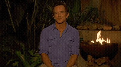 Man In Blue Shirt Sitting By Fire Pit GIF