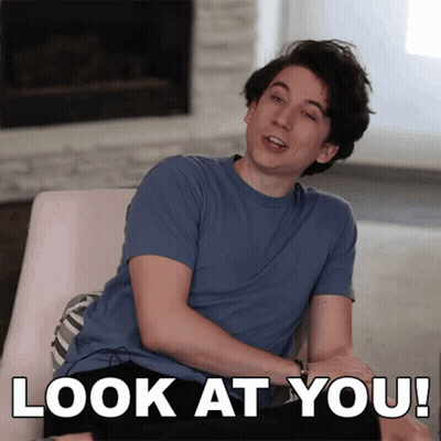 Man In Blue Shirt Sitting By Fireplace Saying Look At You GIF