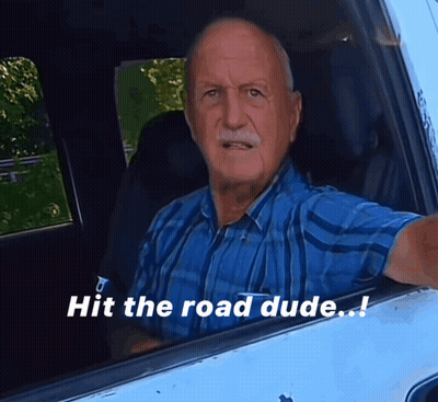 Man in Blue Shirt Sitting in Car Saying Hit the Road Dude