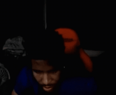 Man In Blue Shirt Sitting In Dark Room With Stuffed Animal GIF