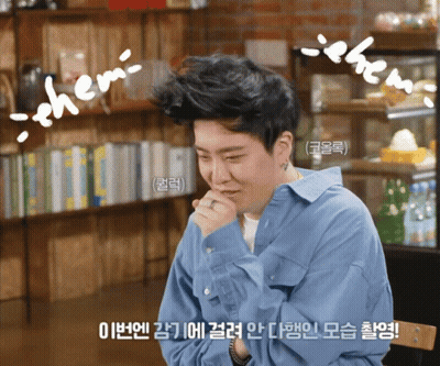 Man In Blue Shirt Sitting In Front Of Bookshelf With Chem On Head GIF