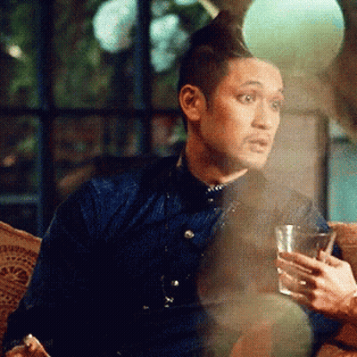 Man In Blue Shirt Sitting On Couch Holding Glass GIF