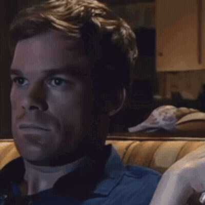 Man In Blue Shirt Sitting On Couch Looking At Something GIF