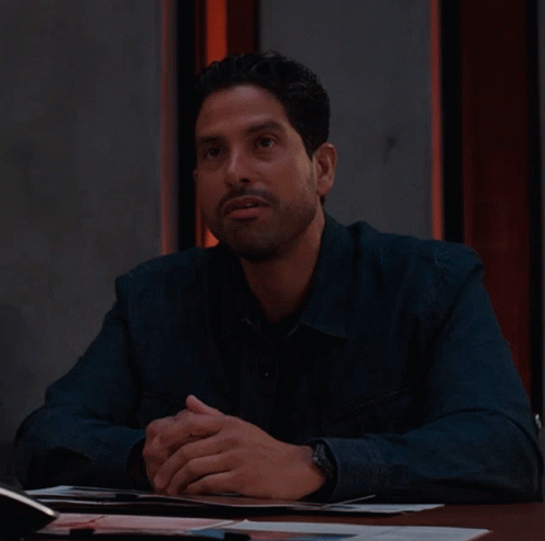 Man In Blue Shirt Sitting With Hands Folded GIF