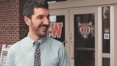 Man In Blue Shirt Smiling In Front Of Building With W GIF