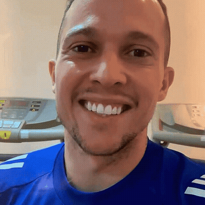 Man In Blue Shirt Smiling In Front Of Treadmill GIF
