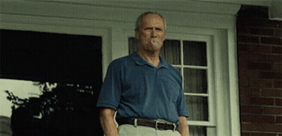 Man In Blue Shirt Smoking Cigarette On Porch GIF