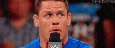 Man In Blue Shirt Speaking Into Microphone GIF