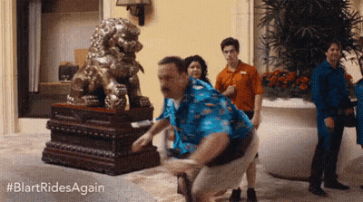 Man In Blue Shirt Squatting In Front Of Lion Statue GIF