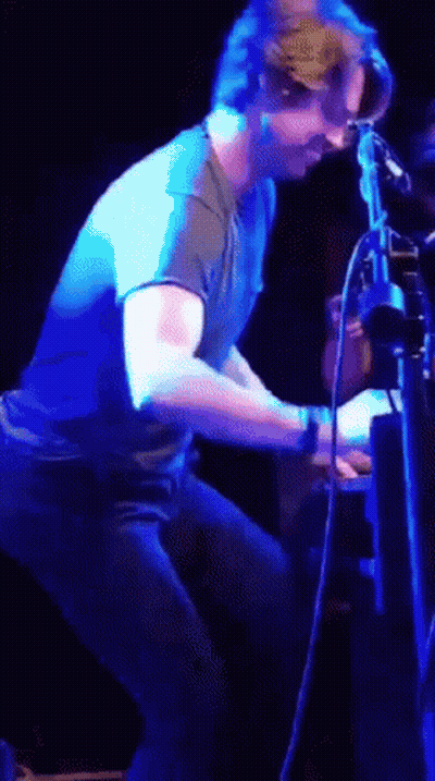 Man In Blue Shirt Standing Before Purple Light GIF
