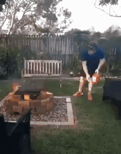 Man In Blue Shirt Standing By Fire Pit GIF