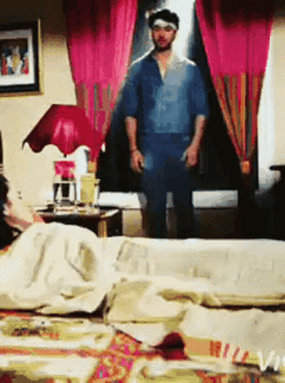 Man In Blue Shirt Standing In Bedroom GIF