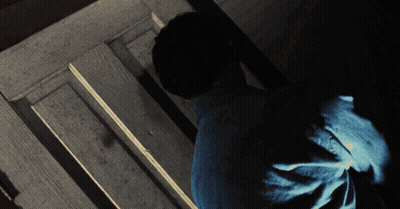 Man In Blue Shirt Standing In Dark Room GIF