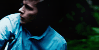 Man In Blue Shirt Standing In Darkness GIF