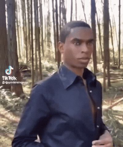 Man In Blue Shirt Standing In Forest GIF