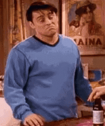 Man In Blue Shirt Standing In Front Of Aina Poster GIF