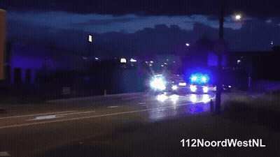 Man In Blue Shirt Standing In Front Of Blue Light GIF