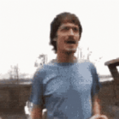 Man In Blue Shirt Standing In Front Of Car GIF