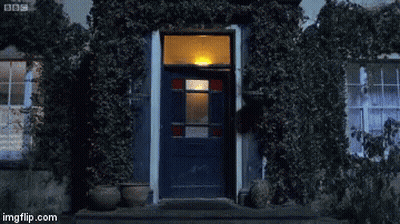 Man In Blue Shirt Standing In Front Of Door GIF