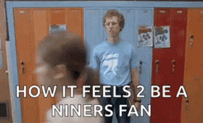 Man In Blue Shirt Standing In Front Of Gym Lockers GIF