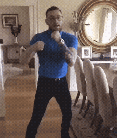 Man In Blue Shirt Standing In Front Of Mirror GIF
