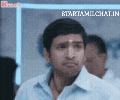 Man In Blue Shirt Standing In Front Of Startamilchat.in Sign GIF