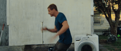 Man In Blue Shirt Standing In Front Of Washing Machine GIF