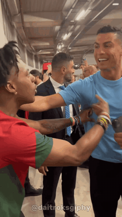 Man In Blue Shirt Standing Next To Another Man GIF
